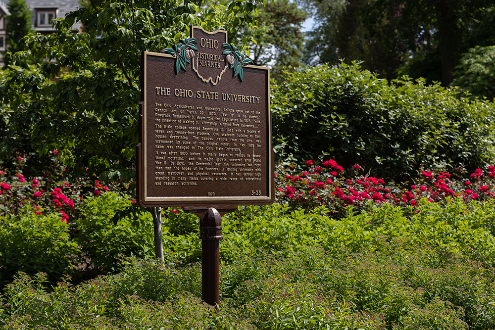 Plaque sign for The Ohio State University surrounded by bushes and shrubs