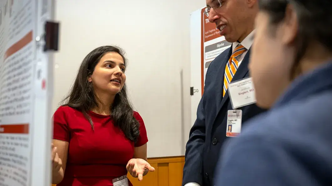 ohio state researcher showing two individuals research papers on a whiteboard