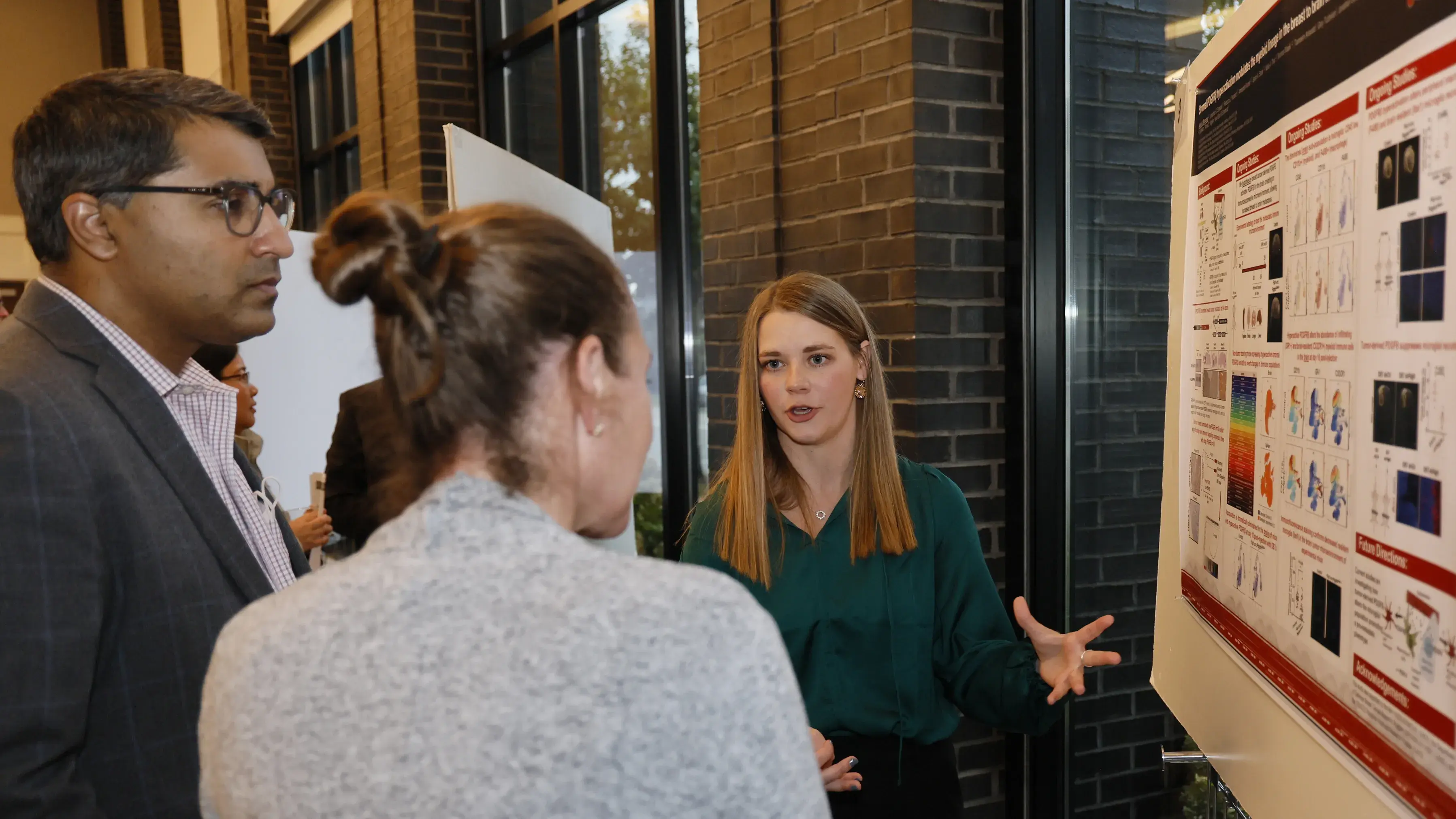 Three people viewing scientific poster